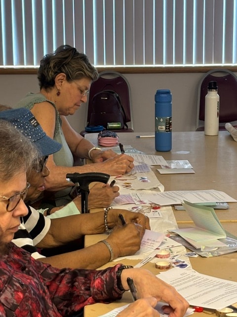 Volunteers focused on writing letters at a workshop